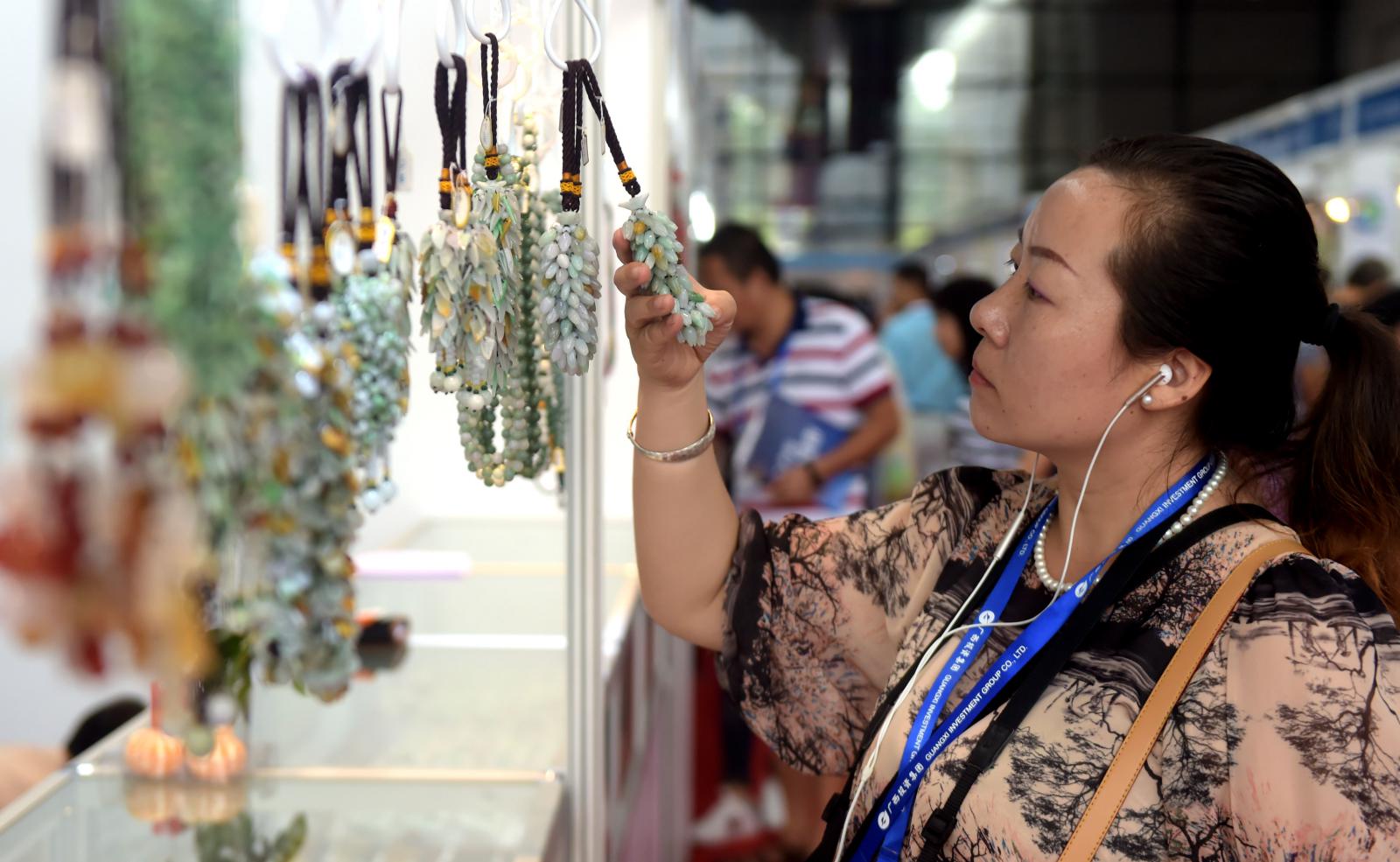 東博會(huì)助力緬甸產(chǎn)品走向中國，圖為消費(fèi)者在東博會(huì)上挑選緬甸玉器飾品